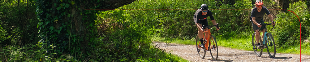 Gravel cyclists riding through a forest